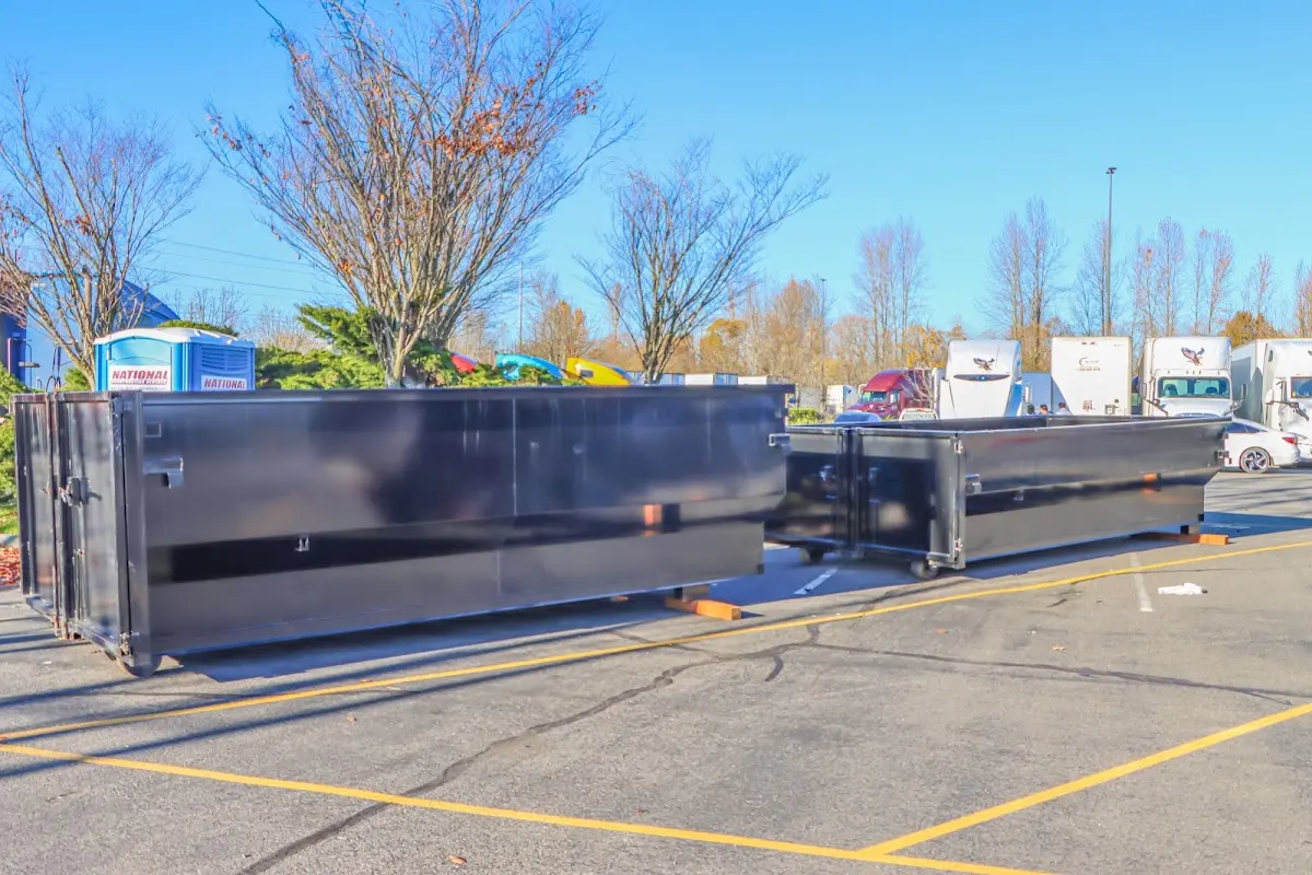 Professional dumpster rental service with roll-off container on residential driveway in St. Albans